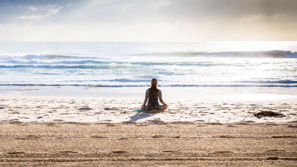Woman on beach looking out to sea